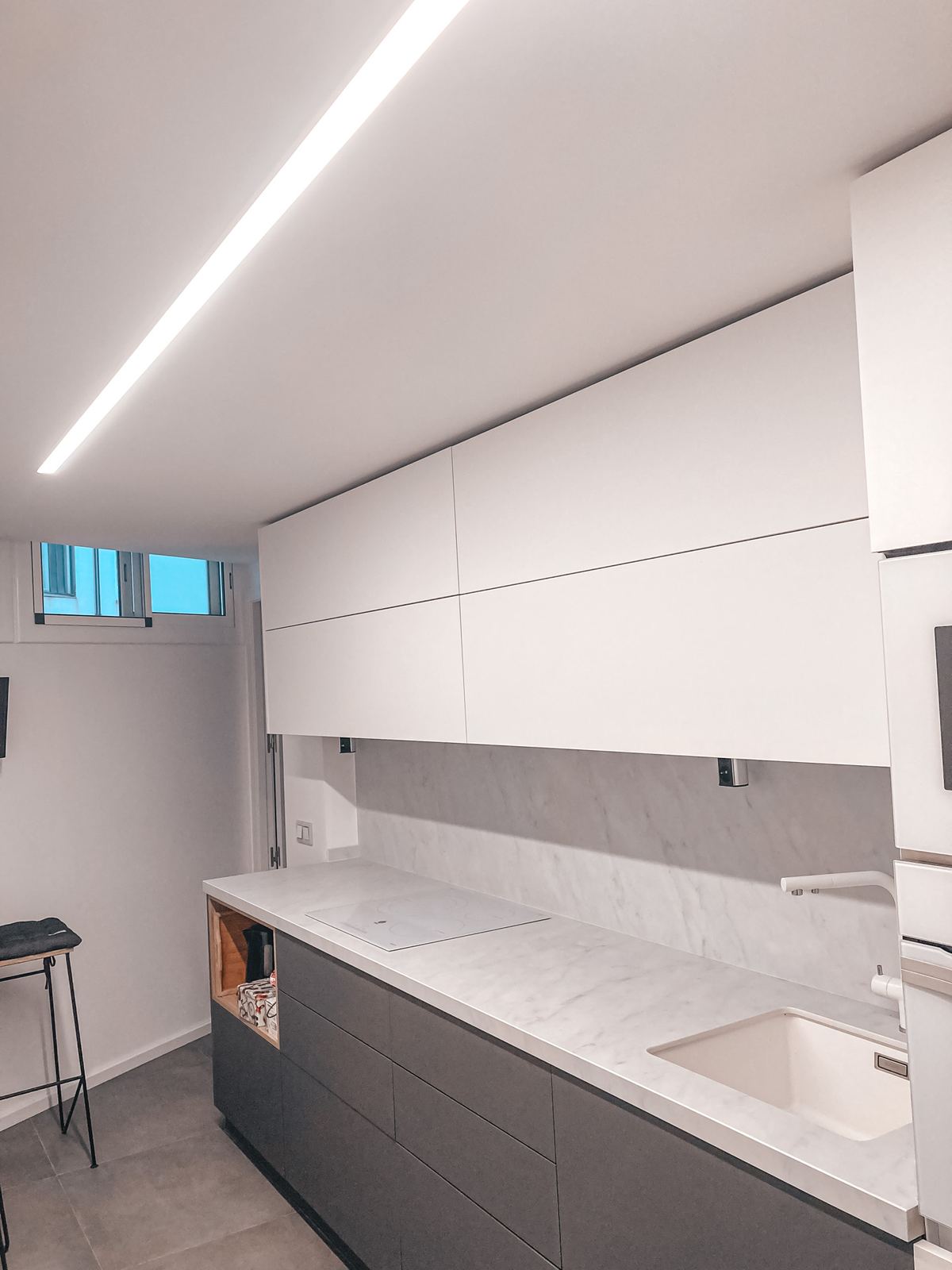 Cuina renovada amb mobles grisos i taulell clar